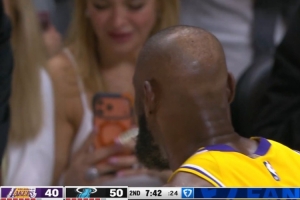 抓紧拍下来！詹姆斯在场边咬牙套调整 场边女球迷拿起手机拍摄 配图