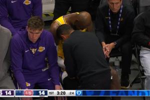 詹姆斯接球戳到小拇指有些受伤 随后下场接受治疗 痛得直咧嘴 配图