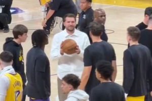 身穿白衬的东契奇在暂停时向队友要球拍一拍 ESPN：他想打球 配图